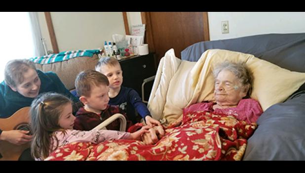 HE’S GOT THE WHOLE WORLD IN HIS HANDS. Rachel Amberson, MT-BC, with Centracare Hospice, shares a special moment as she sings “He’s got the whole world in His hands” with mom and three of her 21 great grandchildren. Isla Porter, Jack Murray and Will Porter. They are pictured at her farmhouse north of Becker just a few days before she passed away. Mom had her eyes closed in this photo, but she was singing along to many of the songs that day! Photo by Mary Nehring. 