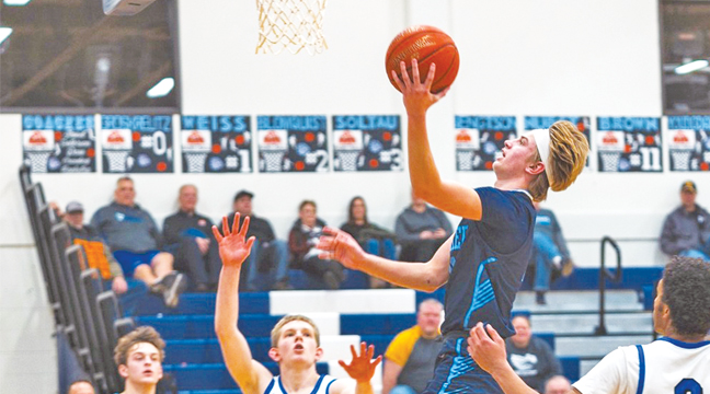 Sawyer Brown has had a stretch of clutch games for the Becker Bulldogs.  He is shown here driving to the basket in the St. Anthony game as teammate Mitchell Soltau (left) looks on. (Submitted Photo).