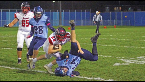 HUNTER KLATT (#14) took on Spartan RB Luke Humbert in this tackle Friday night. Becker’s Landen Goebel (#28) looks on. (Photo by Bill Morgan).