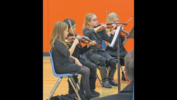 VIOLINISTS CONCENTRATE on getting the notes correct during their first orchestra concert Tuesday. (Photo by Penny Leuthard)