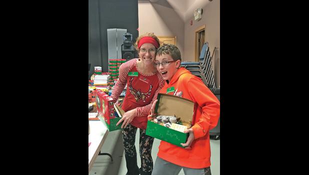 SARAH SCHAFER AND SON WYATT have fun packing their Operation Christmas Child shoeboxes at Oakwood Community Church last Saturday. (Submitted Photo)