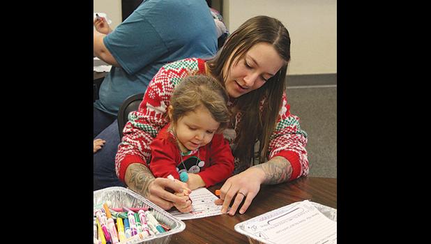 Delilah Hiemenz colored a Christmas card with help from her stepmom, Myranda Phelps.