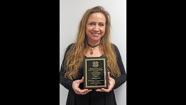 CITIZEN-TRIBUNE REPORTER Penny Leuthard posed with the Clover Coverage Award, given for the best local media coverage of 4-H activities and achievements. (Photo by Bill Morgan).