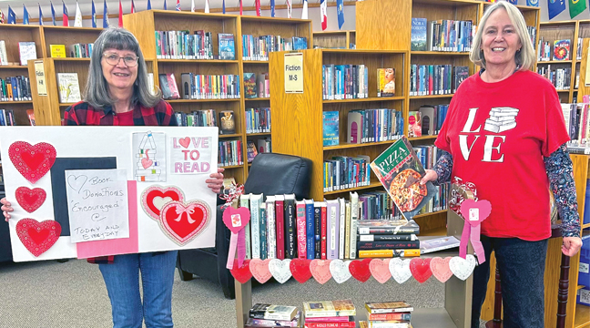 CLEARWATER FRIENDS OF THE LIBRARY MEMBERS Joanne Lisson and Cyrene Bastian with their Valentine’s Day themed book sale display. (Submitted Photo).