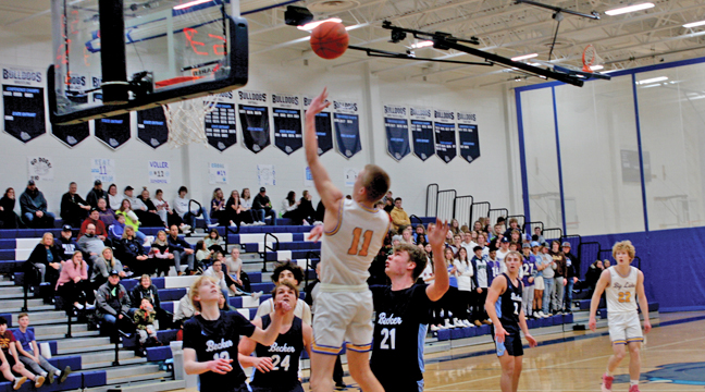 Big Lake’s Kade Layton lofted a shot from the baseline as Becker defenders (from left) Julias Hendricks, Carter Callahan and Hayden Harmoning closed into the lane. (Photo by Mark Kolbinger.)
