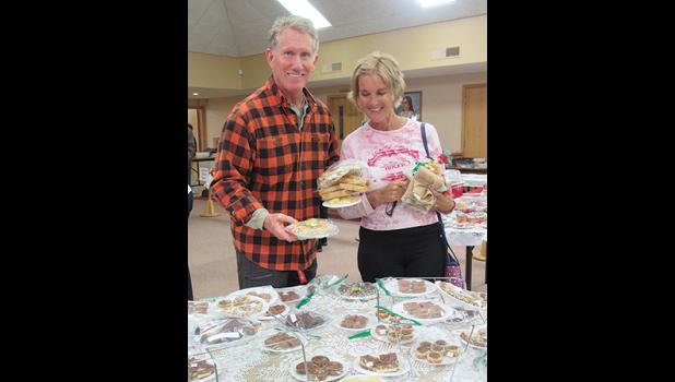 WARREN AND RUTH COWELL load up on goodies Saturday at St. Luke’s Craft and Cookie Stroll. (Photo by Penny Leuthard)
