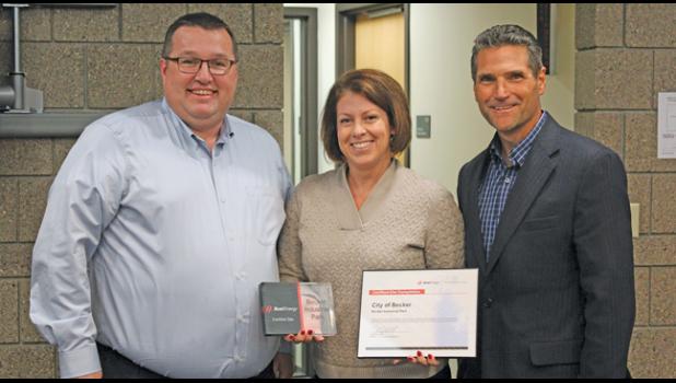 MAYOR TRACY BERTRAM is surrounded by Xcel Energy Engineer Ryan Bruers (L) and Community Relations & Economic Development Manager Mark Osendorf (R) after receiving two awards for site program partnering with the company. (Photo by Bill Morgan)
