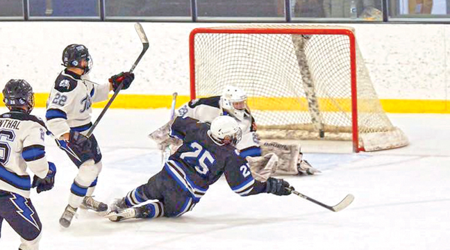 Becker/Big Lake Eagles hockey player (#25) Tate Spilde, trying to score a goal on the Tartan Titans as he was tripped up. (Submitted Photo).