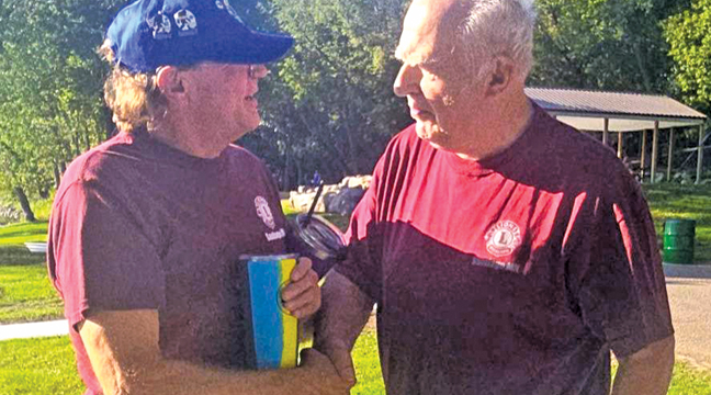 SEVERAL SANTIAGO LIONS MEMBERS were on hand to show support to the Becker Lions. Mark Renn greeted Ingvar Larsén at Snuffy’s Landing. (Patriot Photo by Mary Nehring.)