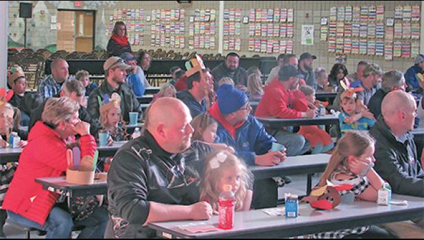 BECKER FIRST-GRADERS AND THEIR DADS learn about the Watch D.O.G.S. program and how they can become involved. (Photo by Penny Leuthard)