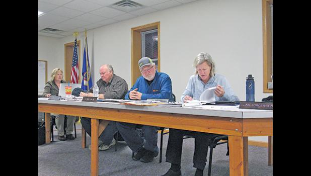 Lynden Twp. Supervisors Dave Johnson, Dennis Niemi and Anne Ackerman review road maintenance contracts during their meeting Monday night. (Photo by Penny Leuthard)