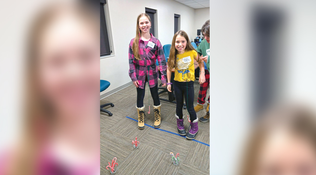 Club members Elsie & Emmie play the candy cane crane game. (Submitted Photo).