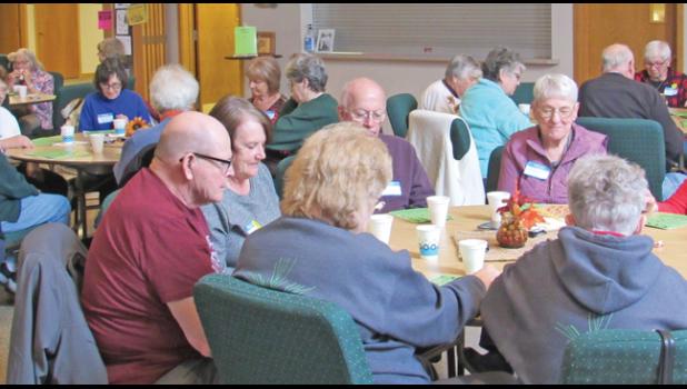 ATTENDEES OF YOUNG AT HEART’S recent grocery bingo event watch their cards closely for matching numbers. (Photo by Penny Leuthard)