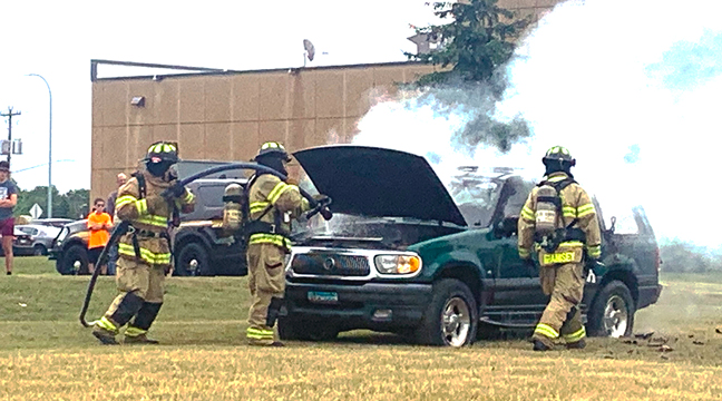 SPECTATORS LINE UP to watch a car fire demonstration during the open house. (Photo by Penny Leuthard.)