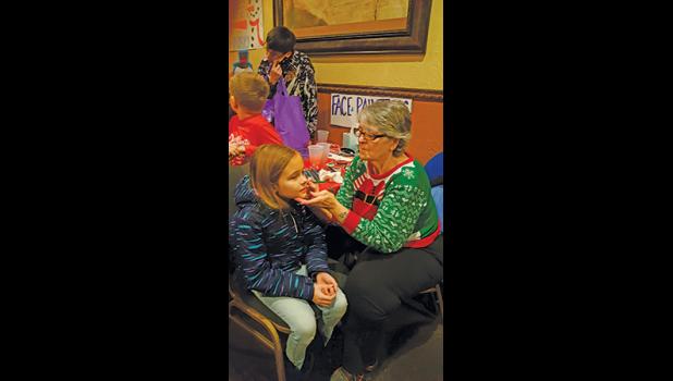 THE FACE PAINTING ARTIST had fun decorating kids faces at the Christmas party Saturday. (Submitted photos). 