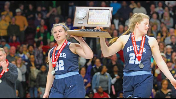 SENIORS  AMBER VOGL (L) and Lexi Masog (R) proudly carry the runner-up trophy off the court after Becker’s championship loss to DeLaSalle in March. (Photo by Bill Morgan).