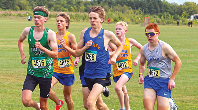 Gavin Flavin (center) runs in the lead pack at the Monticello Invitational Saturday. The senior placed third and led the Hornet team to a third place finish. (Photo by Ken Francis.)