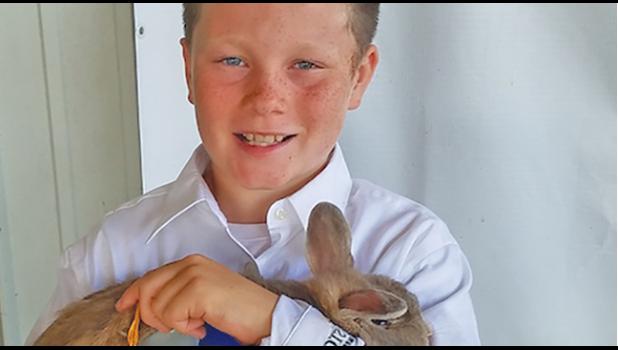 OWEN MCFADDEN with his rabbit that he showed at the fair, winning a blue ribbon and honorable mention for showmanship. (Submitted Photo)
