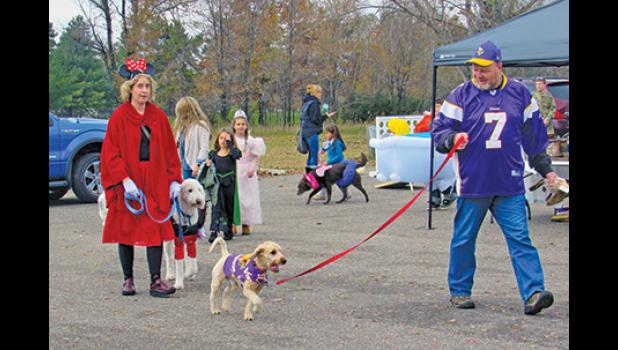 MANY OF THE OWNERS matched their pets during Becker Community Center’s Barktober Fest pet costumer parade, like these Viking fans and Minnie Mouse characters. (Photo by Penny Leuthard)