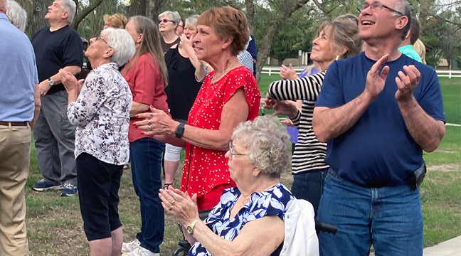 Kathy Nelson (L) and her mom, Louise Wheeler, clapped as they watched the balloons drift away at last week’s cancer survivor’s dinner. (photo by Mark Kolbinger.)
