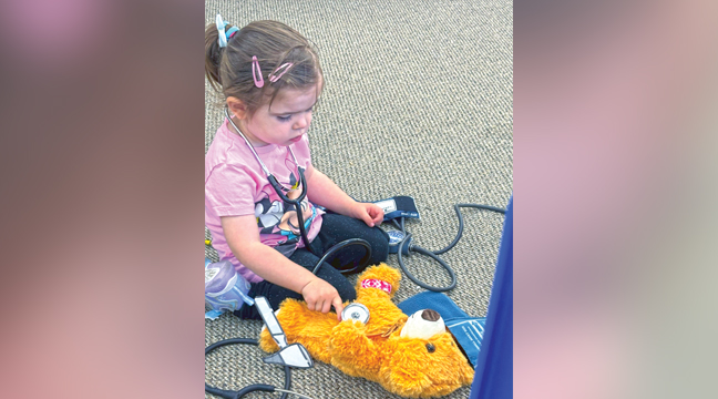 ZIBA J. LISTENS FOR HER BEAR’S HEARTBEAT during the Teddy Bear Clinic at the Clearwater Library. (Patriot Photos by Penny Leuthard)