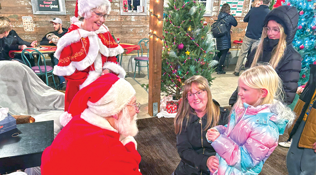 It was a busy evening for Santa and Mrs. Claus, as the children were lined up waiting to share their Christmas lists. (Patriot Photo by Mark Kolbinger).