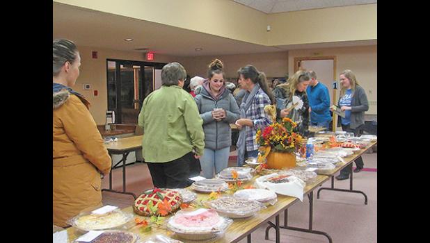 ATTENDEES CHECK OUT THE SELECTION OF DONATED PIES before the start of the 10th annual Slice for Life pie auction Tuesday at St. Luke’s in Clearwater. (Photos by Penny Leuthard)