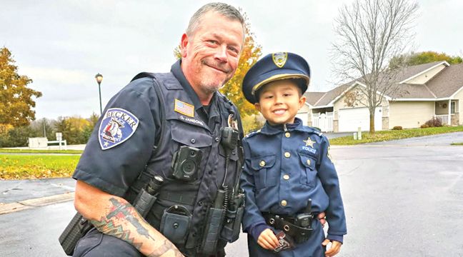 Lennox Kruchten,  son of Brent and Avril Kruchten, is pictured on Halloween night with Becker police officer, Grant Jansons. (Submitted Photo).