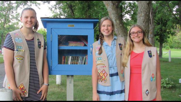 GIRL SCOUTS Meghan Swanson, Delaney Varney and Gabby Artman with the first of the “Little Libraries” they installed as part of their Girl Scout Silver Award project, this one at Palmer Park.  (Photo by Penny Leuthard)