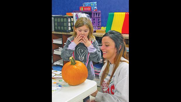 CHELSIE L. (L) AND HER MOM, KALI (R), react to Chelsie’s pumpkin decorating creation. (Photo by Penny Leuthard).