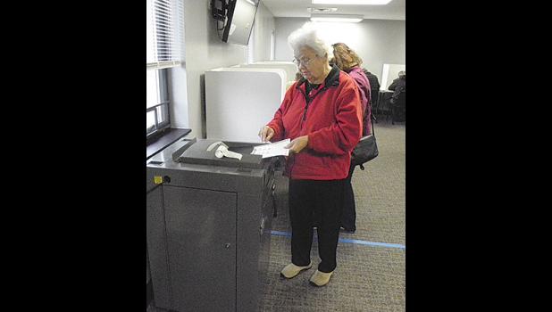 Shirley Weber feeds her ballot into the voting machine at Clearwater City Hall Tuesday morning. (Photo by Ken Francis).