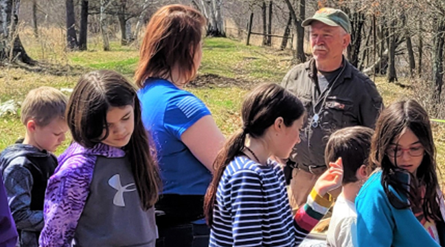 Mom and students quizzing Dr. Jim Mead on the bank of the Snake River.