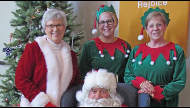 BRINGERS OF HOLIDAY CHEER Santa and Mrs. Claus (Doc and Jane Gohman) and their helpers, elves Tara Maile and Becky Brzezinski during the December Young at Heart event. (Photo by Penny Leuthard)