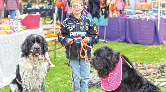 RYDER posed with two Newfoundlands  during Saturday’s Barktober festivities at Becker City Park. Ryder is the son of one of the owners of Canine Cabin, a lodging, training, grooming  company located in Clear Lake. (Patriot Photo by Bill Morgan)